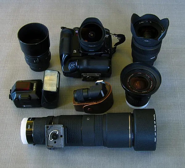 Big boys, big toys - This is a part of my SLR equipment. The camera is a digital Konica Minolta 7D and the lenses range from 16mm wide to 300mm telephoto (450 with a converter). Also seen is the flash and an angle finder. Toting this around on a fishing trip will add about 5.5 kilos or 11 lbs to your carrying weight.